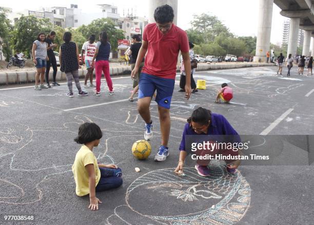 Children draw illustration on roadside during Raahgiri Day at Sector 55 Golf Course Road, an event organised by MCG, on June 17, 2018 in Gurugram,...