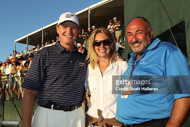 Ernie Els of South Africa poses with his wife Liezl and his manager Andrew 'Chubby' Chandler on the 18th hole after winning the 2010 WGC-CA...