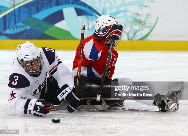 Tim Jones of the United States controls the puck against Pavel Kubes of the Czech Republic during the first period of the Ice Sledge Hockey...