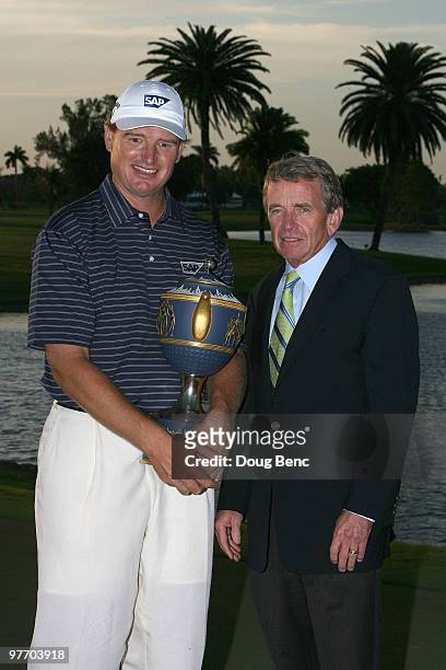 Ernie Els of South Africa holds the Gene Sarazen Cup trophy with Tim Finchem, Commissioner of the PGA TOUR after winning the 2010 WGC-CA Championship...