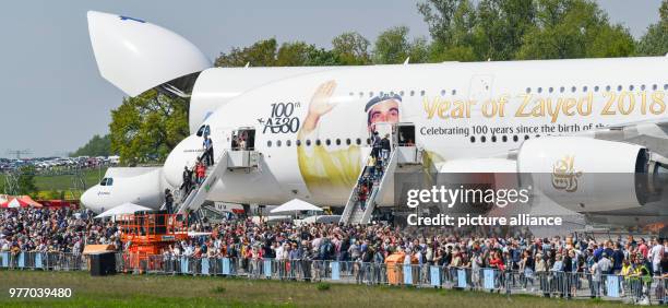 April 2018, Germany, Schoenefeld: Many visitors walking through the ILA 2018 - with an Airbus A380 with special markings showing Sheikh Zayed bin...