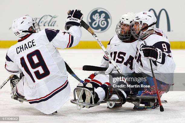 Taylor Lipsett of the United States celebrates his first period goal with teammates Taylor Chase and Andy Yohe during the Ice Sledge Hockey...