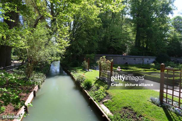 April 2018, Germany, Augsburg: A canal with water from the Lechs running along the herbal garden at the 'Red Gate'. The city of Augsburg has applied...