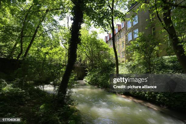 April 2018, Germany, Augsburg: A canal running through a green area on the edge of the old town. The city of Augsburg has applied as 'Wasserbau und...