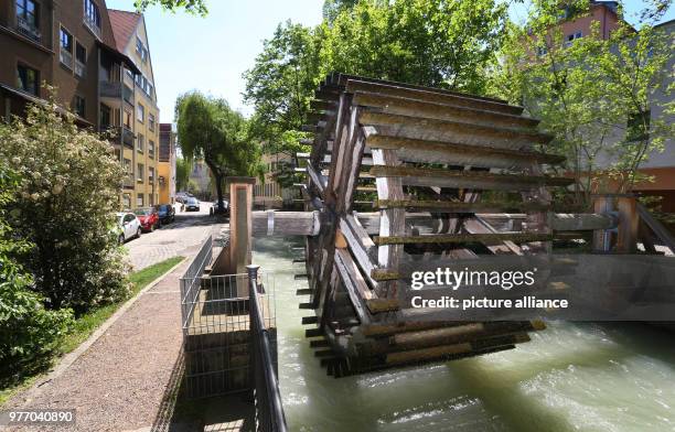 April 2018, Germany, Augsburg: A water wheel made of oak being moved by water. The city of Augsburg has applied as 'Wasserbau und Wasserkraft,...