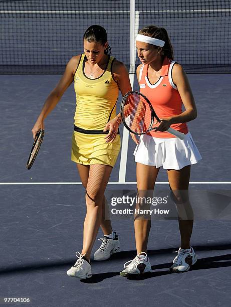 Gisela Dulko of Argentina and Flavia Pennetta of Italy talk after a lost point against Nuria Llagostera Vives of Spain and Maria Jose Martinez...