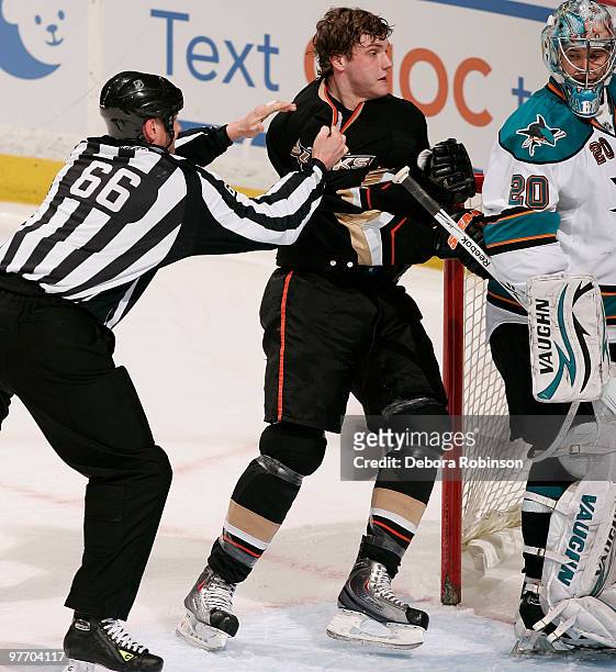 Bobby Ryan of the Anaheim Ducks is pulled away from fighting with Dan Boyle of the San Jose Sharks by linesman Darren Gibbs during the game on March...