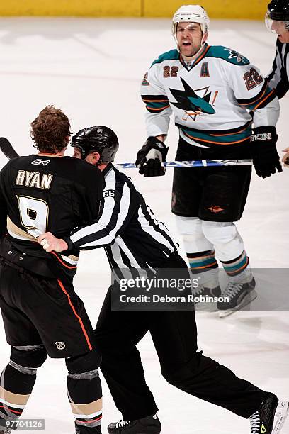 Bobby Ryan of the Anaheim Ducks is pulled away from fighting by linesman Darren Gibbs as Dan Boyle of the San Jose Sharks yells back during the game...