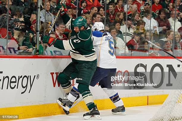 Kyle Brodziak of the Minnesota Wild and Barret Jackman of the St. Louis Blues battle for the puck along the boards during the game at the Xcel Energy...