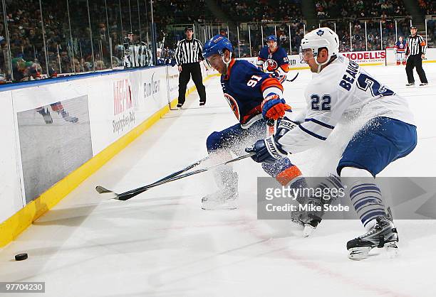 John Tavares of the New York Islanders and Francois Beauchemin of the Toronto Maple Leafs battle for the puck on March 14, 2010 at Nassau Coliseum in...