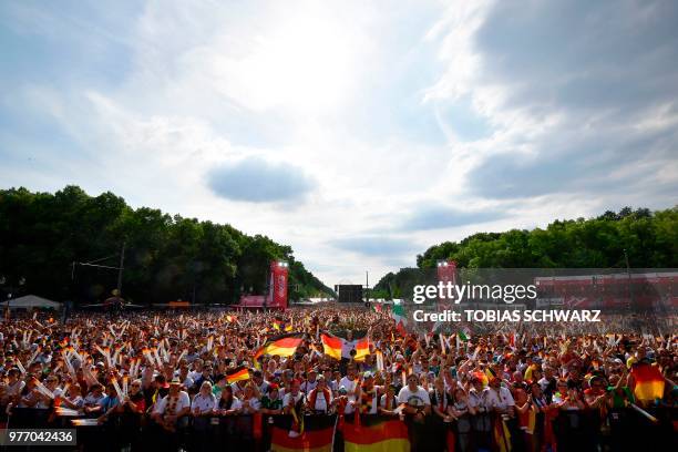 Fans of the German team wave flags during a public viewing event at the "Fanmeile" area in front of Berlin's landmark Brandenburg Gate on June 17...