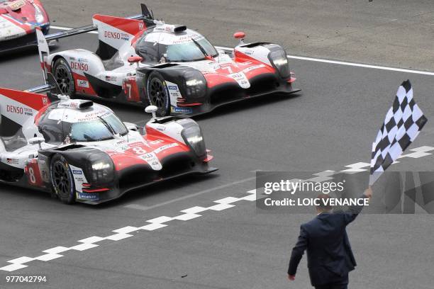 Toyota TS050 Hybrid LMP1 Japanese's driver Kazuki Nakajima crosses the finish line to win ahead Toyota TS050 Hybrid LMP1 Japan's driven by Kamui...