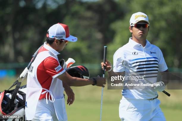 Hideki Matsuyama of Japan takes a club from caddie Daisuke Shindo as he prepares to play a shot on the third green during the final round of the 2018...