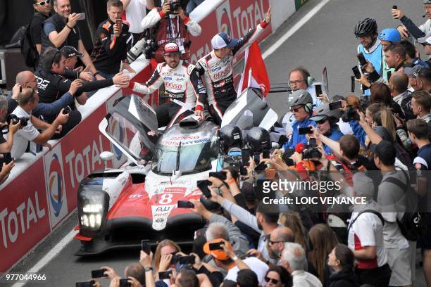 Toyota TS050 Hybrid LMP1's drivers Spain's Fernando Alonso and Switzerland's Sebastien Buemi celebrate after winning the 86th edition of the 24h du...