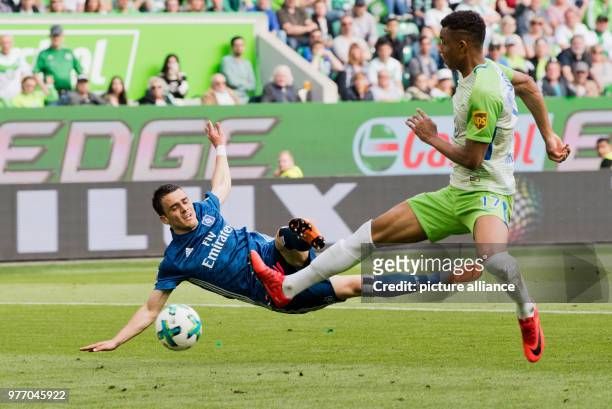 Hamburg's Andre Hahn shots at goal with before Wolfsburg's Ohis Felix Uduokhai during the German Bundesliga soccer match between VfL Wolfsburg and...