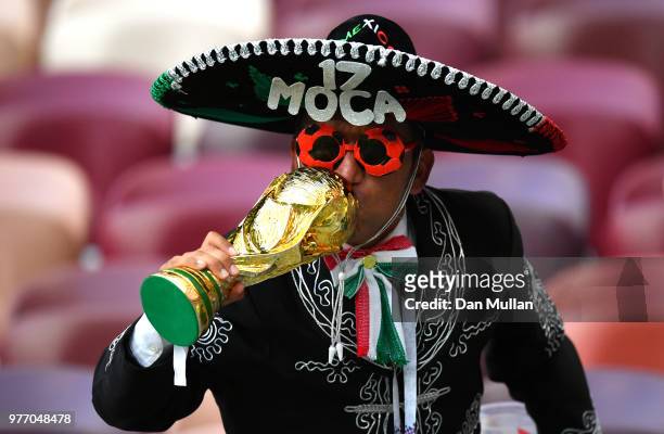Mexico fan kisses a replica World Cup Trophy following his sides victory in the 2018 FIFA World Cup Russia group F match between Germany and Mexico...