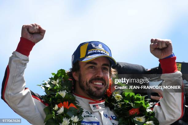 Spain's driver Fernando Alonso celebrates on the podium after he and his co-drivers won the 86th Le Mans 24-hours endurance race, at the Circuit de...