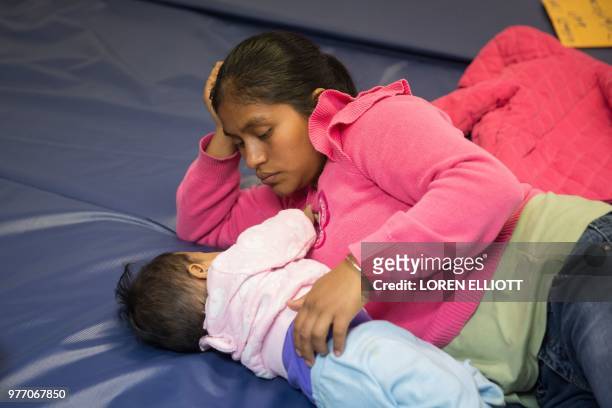 Guatemalan woman and her infant daughter seeking asylum pass the time at a Catholic Charities relief center on Sunday, June 17, 2018 in McAllen,...