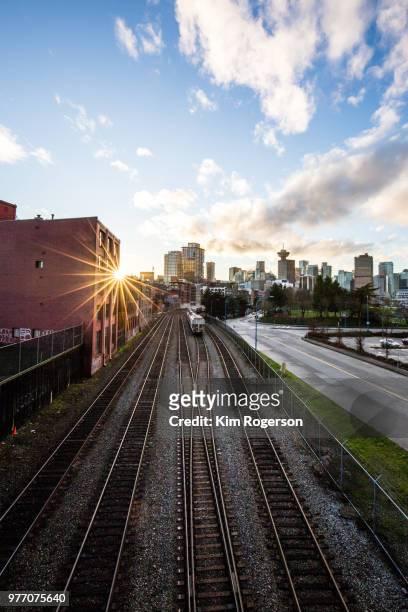 sunburst on railroad tracks await the transport trains into vancouver - east vancouver stock pictures, royalty-free photos & images