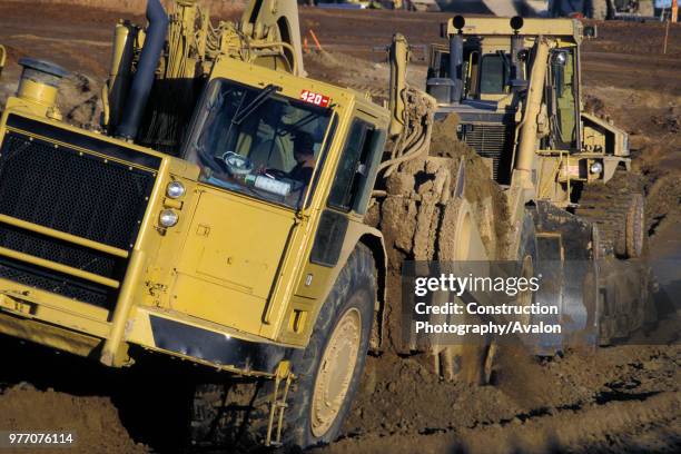 Bulldozer pushing scraper on highway widening project, Fresno County, California, USA.