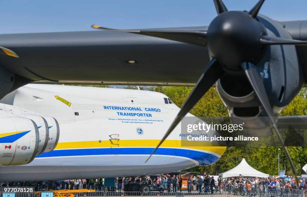 April 2018, Germany, Schoenefeld: Many visitors walk across the grounds of the ILA Berlin Air Show 2018 with the world's biggest cargo aircrafts, an...