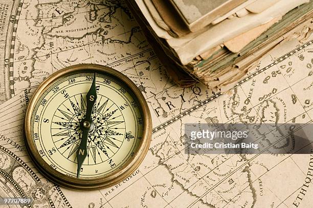 old compass over ancient map - compas stock-fotos und bilder