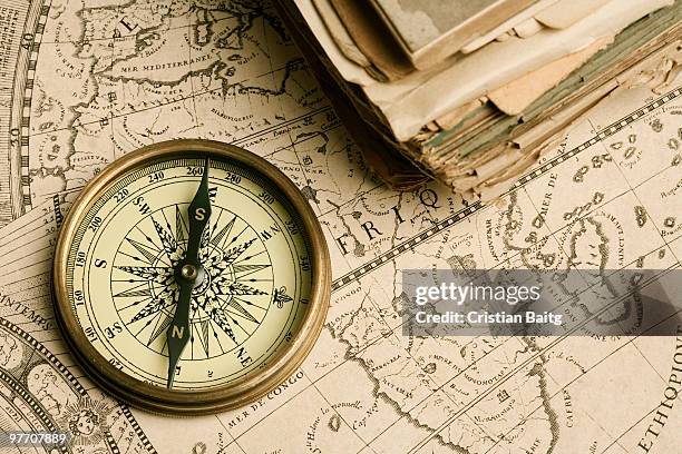 old compass over ancient map - navigational compass stockfoto's en -beelden