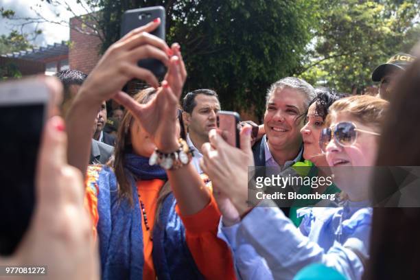 Ivan Duque, presidential candidate for the Democratic Center Party, third right, takes selfie photographs with voters outside of a polling center...