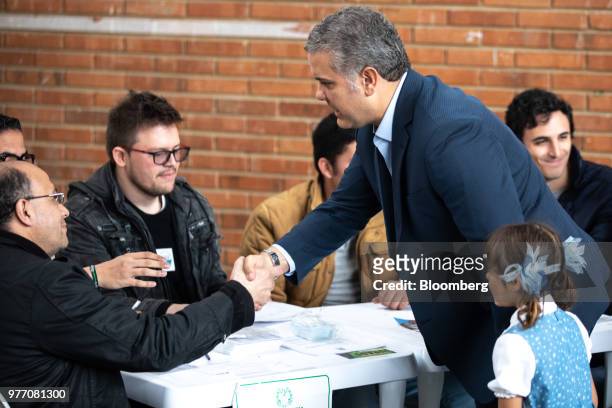Ivan Duque, presidential candidate for the Democratic Center Party, right, greets polling officials while arriving to cast his ballot inside a...