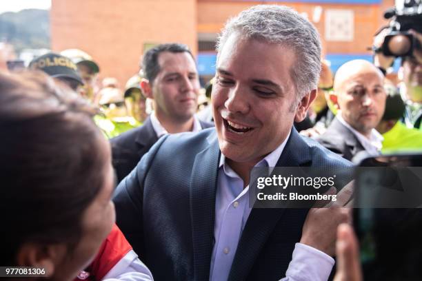 Ivan Duque, presidential candidate for the Democratic Center Party, center, greets a voter outside of a polling center during the second round of...