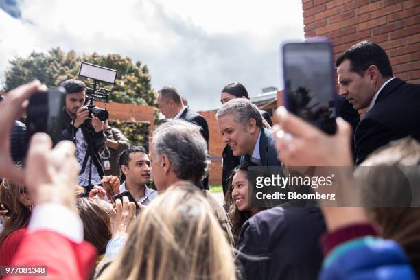 Ivan Duque, presidential candidate for the Democratic Center Party, center, greets voters outside of a polling center during the second round of...
