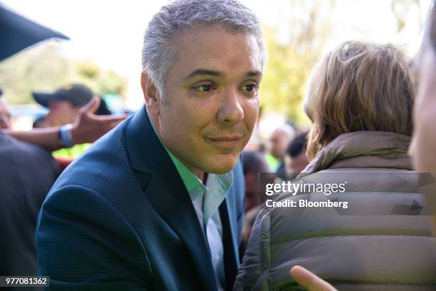 Ivan Duque, presidential candidate for the Democratic Center Party, listens as a voter speaks outside of a polling station during the second round of...