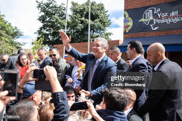 Ivan Duque, presidential candidate for the Democratic Center Party, center, greets voters outside of a polling center during the second round of...