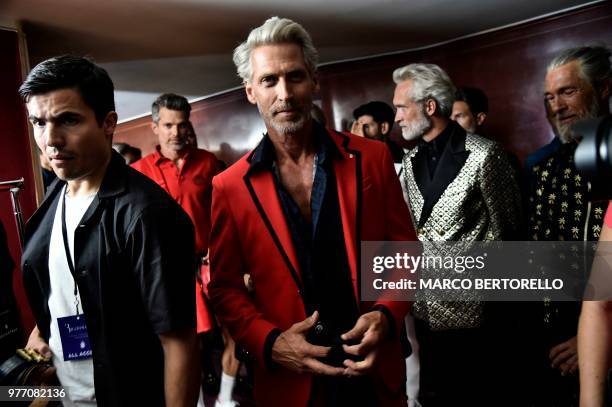 Models pose in the backstage before the show of fashion house Billionaire during the Men's Spring/Summer 2019 fashion shows in Milan, on June 17,...