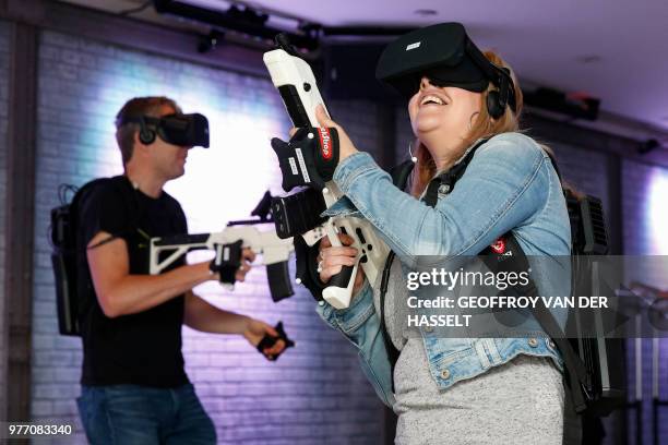 People play an immersive RP shooter collaborative virtual reality game during an "escape game" session on June 11 in Puteaux, near Paris. -...