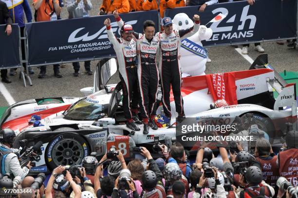 Toyota TS050 Hybrid LMP1 drivers Spain's driver Fernando Alonso , Japan's Kazuki Nakajima and Switzerland's Sebastien Buemi celebrate after winning...