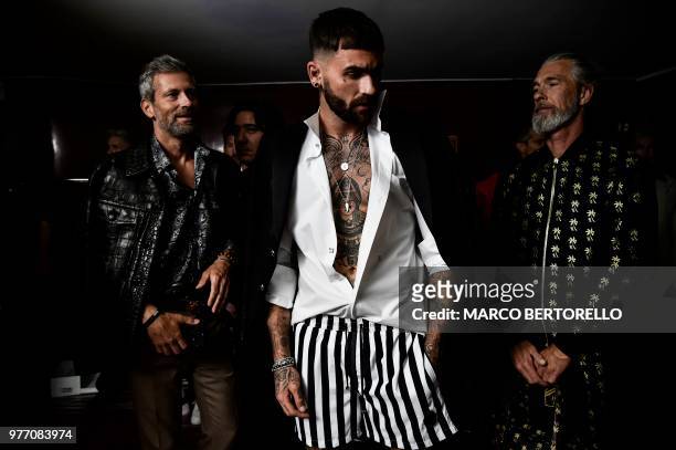 Models pose in the backstage before the show of fashion house Billionaire during the Men's Spring/Summer 2019 fashion shows in Milan, on June 17,...