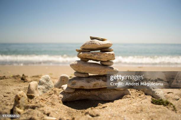 stack of stones on sandy beach, costinesti, romania - costinesti stock pictures, royalty-free photos & images