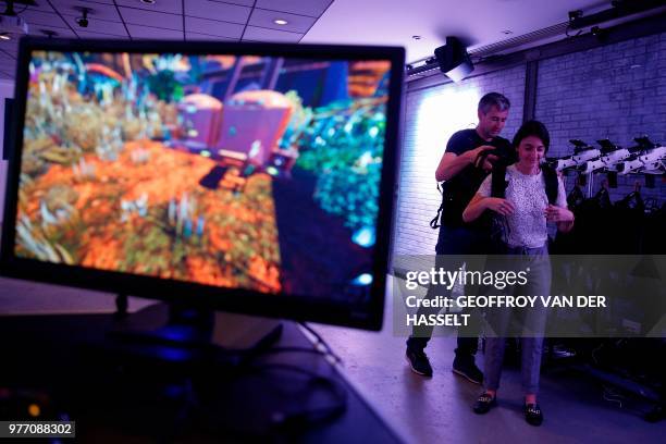 People play an immersive RP shooter collaborative virtual reality game during an "escape game" session on June 11 in Puteaux, near Paris. -...