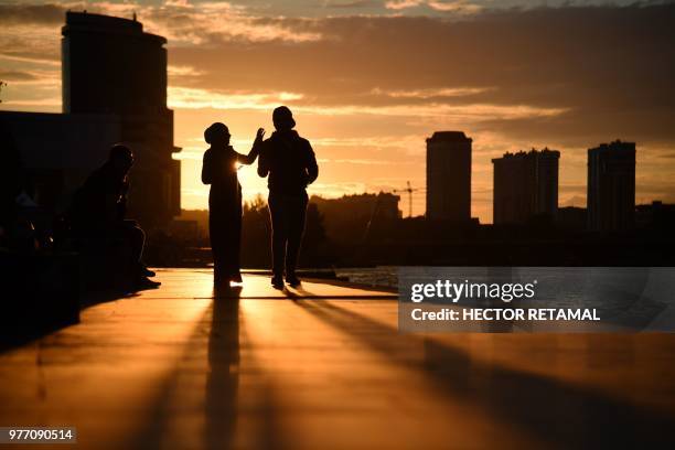 Couple walk next to Iset River in Ekaterinburg city on June 17 during the Russia 2018 World Cup football tournament.