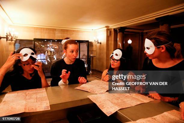 An actress speaks to people taking part in an "escape game" session at the Opera Garnier in Paris, on June 4, 2018. - Participants of these games are...