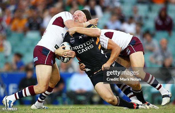 Keith Galloway of the Tigers is tackled during the round one NRL match between the Wests Tigers and the Manly Warringah Sea Eagles at the Sydney...