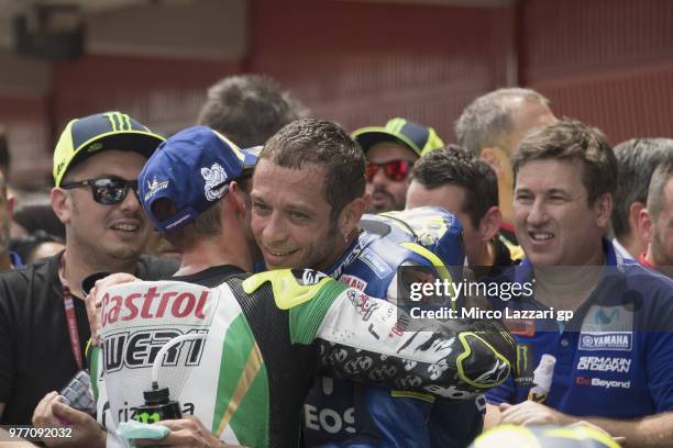 Cal Crutchlow of Great Britain and LCR Honda celebrates with Valentino Rossi of Italy and Movistar Yamaha MotoGP under the podium at the end of the...