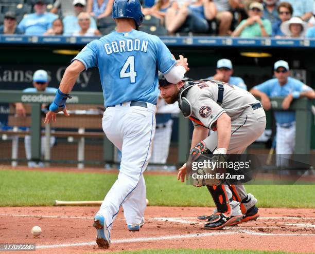 Alex Gordon of the Kansas City Royals heads home to score against Brian McCann of the Houston Astros in the first inning at Kauffman Stadium on June...