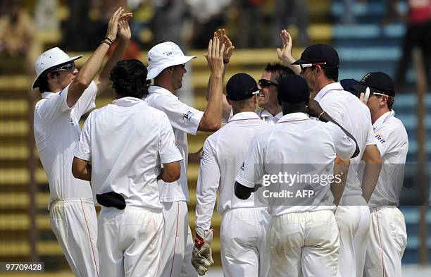 England cricketers celebrate dismissal of the unseen Bangladeshi cricket captain Shakib Al Hasan during the fourth day of the first Test match...