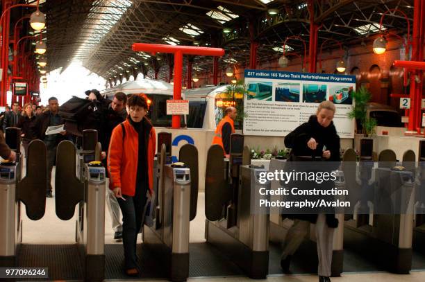 Passengers walk through the ticket barriers at Marylebone having arrived on a local service. February 2005, United Kingdom.