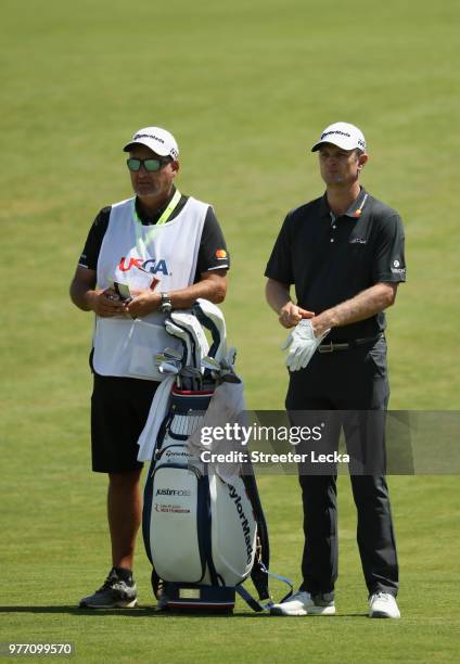 Justin Rose of England waits to take his shot on the third green with caddie Mark Fulcher during the final round of the 2018 U.S. Open at Shinnecock...