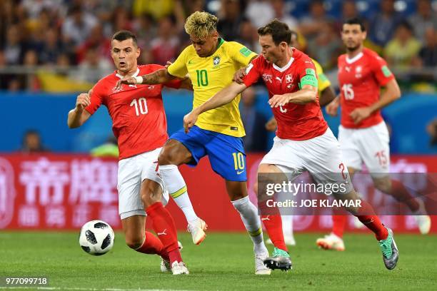Switzerland's midfielder Granit Xhaka , Brazil's forward Neymar and Switzerland's defender Stephan Lichtsteiner compete for the ball during the...