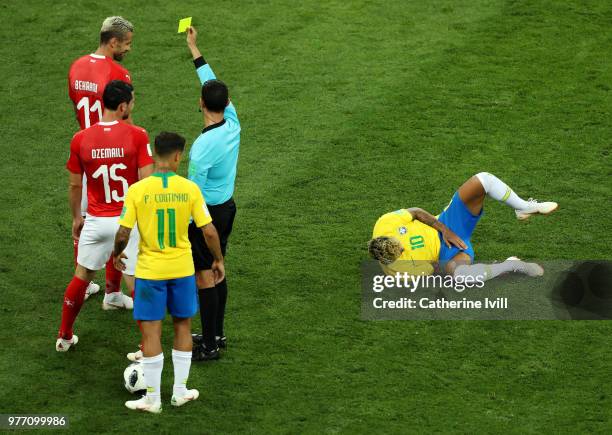 Referee Cesar Ramos shows Valon Behrami of Switzerland a yellow card for a foul of Neymar Jr of Brazil during the 2018 FIFA World Cup Russia group E...