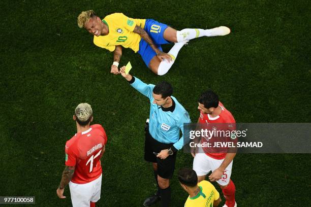 Referee Cesar Ramos shows a yellow card to Switzerland's midfielder Valon Behrami after a tackle on Brazil's forward Neymar during the Russia 2018...